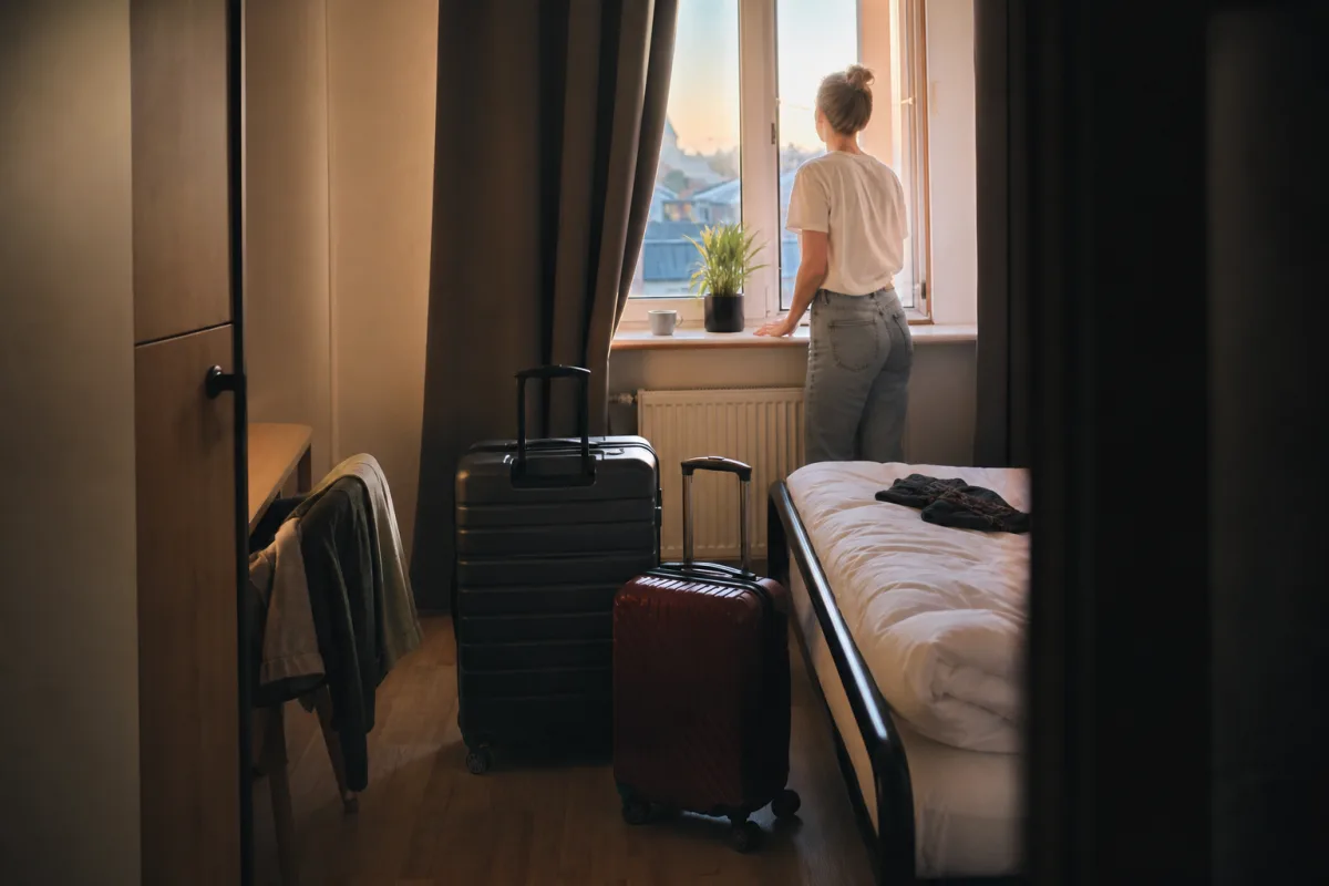Privatrum på hostel med två resväskor, kvällsljus genom fönstret