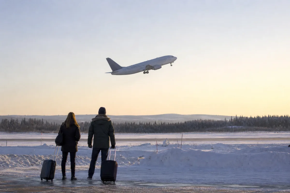 Flygplan lyfter från en mindre regional flygplats i vinterljus